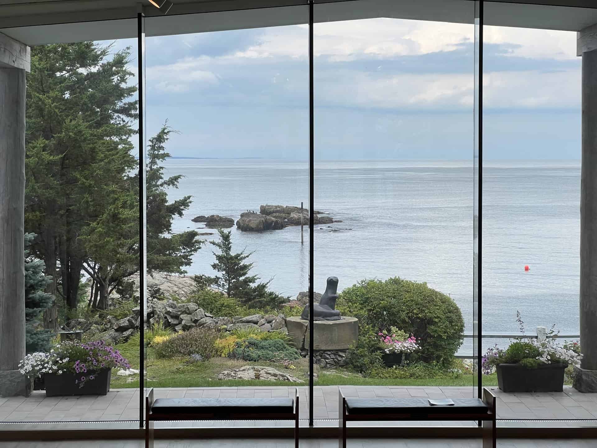 a large glass window with two benches and view of the ocean