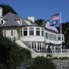 A white building and an american flag and a blue flag 